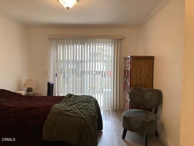 bedroom featuring crown molding and light hardwood / wood-style flooring