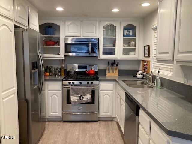 1340 E Hillcrest Dr Unit 8, Thousand Oaks, CA 91362 - kitchen with stainless steel appliances, white cabinetry, glass insert cabinets, light wood-style floors, and recessed lighting
