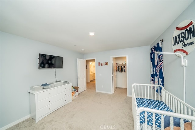 carpeted bedroom with a spacious closet and a closet