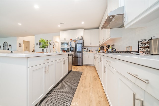 kitchen featuring white cabinets, stainless steel appliances, and light wood-type flooring