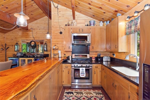 kitchen with sink, appliances with stainless steel finishes, lofted ceiling with beams, and wood walls