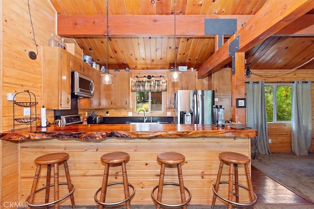 kitchen featuring wood ceiling, stainless steel appliances, wood-type flooring, and decorative light fixtures