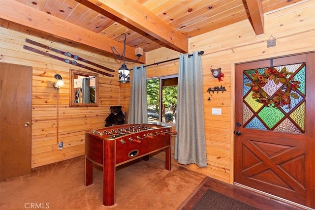 playroom featuring beam ceiling, wooden walls, and carpet