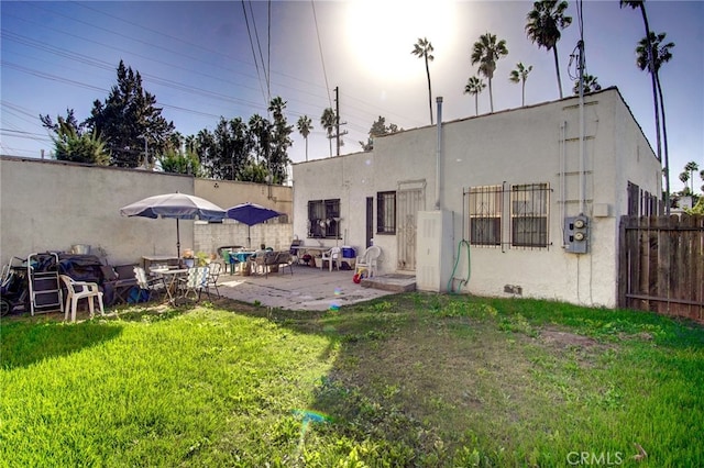 back of house featuring a patio and a lawn