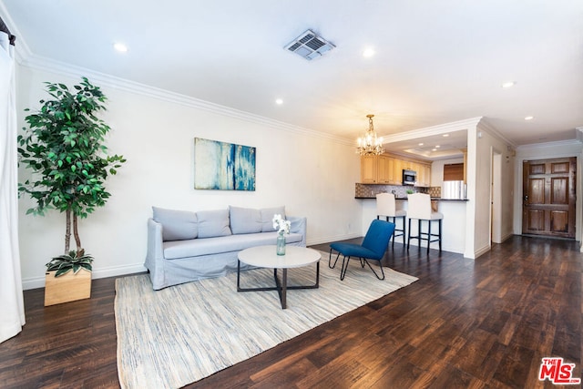 living room with an inviting chandelier, crown molding, and hardwood / wood-style flooring