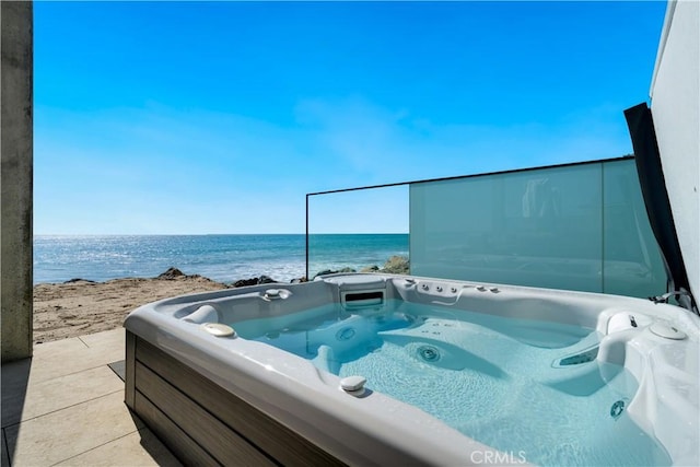 view of patio featuring a water view and a hot tub