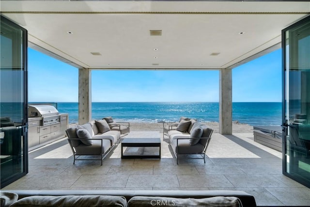 view of patio with outdoor lounge area, a grill, and a water view