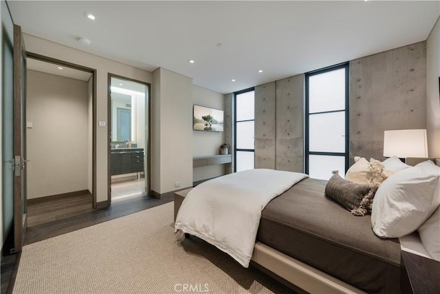 bedroom featuring dark hardwood / wood-style floors and ensuite bath