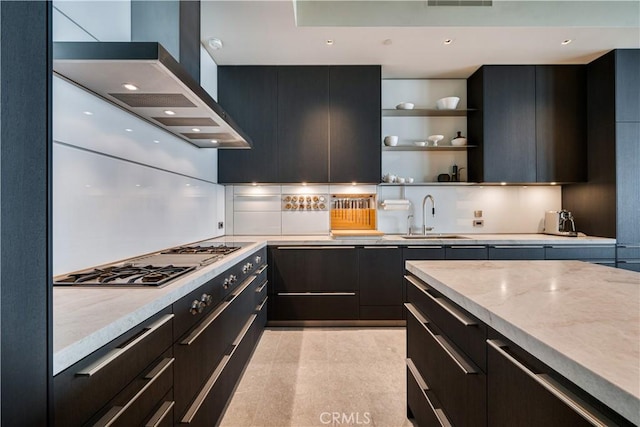 kitchen with light stone countertops, sink, ventilation hood, stainless steel gas stovetop, and light tile patterned floors