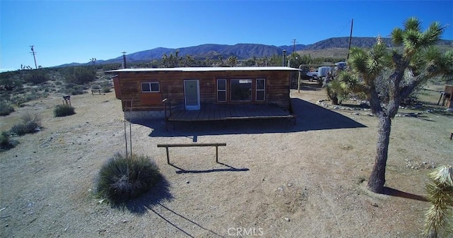 back of property featuring a deck with mountain view