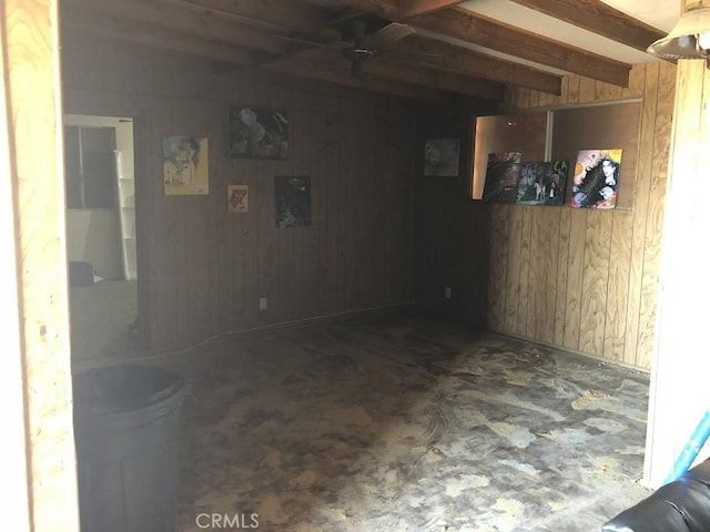 interior space with ceiling fan and wooden walls