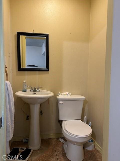 bathroom featuring tile patterned flooring, toilet, and sink