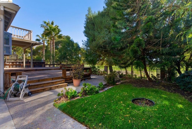 view of yard featuring a patio, a fire pit, and a wooden deck