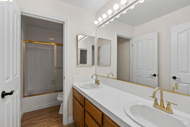 full bathroom featuring vanity, enclosed tub / shower combo, wood-type flooring, and toilet