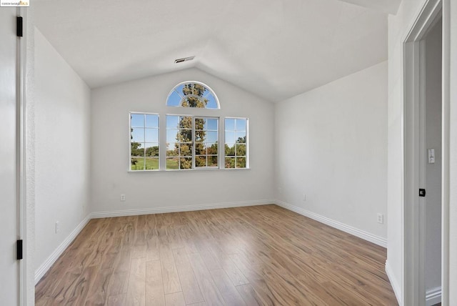 unfurnished room featuring light hardwood / wood-style flooring and lofted ceiling