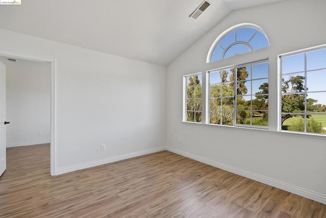 empty room featuring vaulted ceiling and light hardwood / wood-style flooring