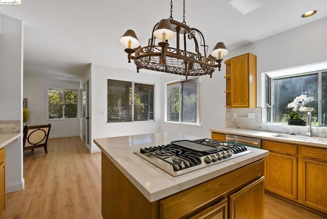 kitchen featuring light hardwood / wood-style flooring, a healthy amount of sunlight, appliances with stainless steel finishes, and an inviting chandelier