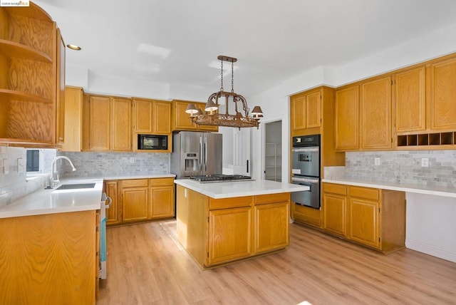 kitchen featuring a kitchen island, hanging light fixtures, stainless steel appliances, light wood-type flooring, and tasteful backsplash