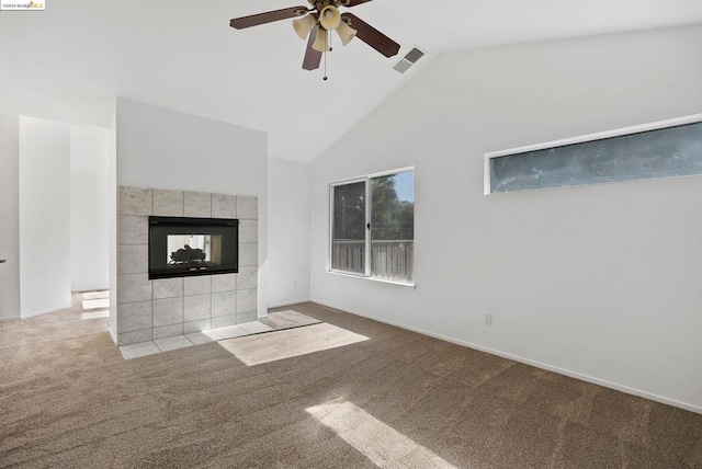 unfurnished living room with light carpet, high vaulted ceiling, a tile fireplace, and ceiling fan