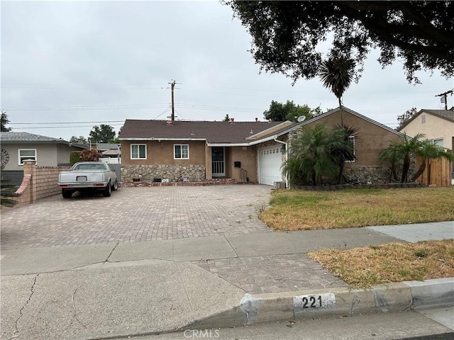 single story home featuring a front yard and a garage