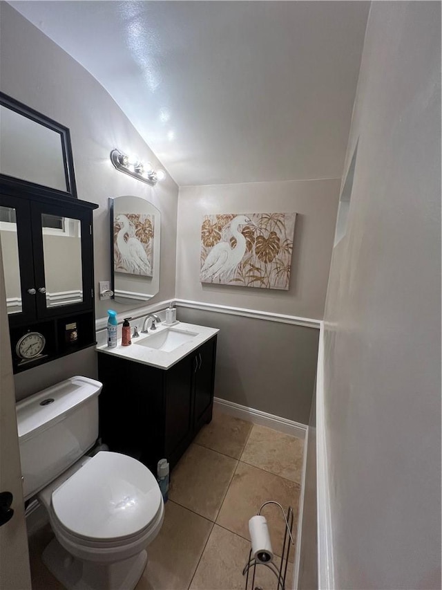 bathroom featuring tile patterned flooring, vanity, vaulted ceiling, and toilet