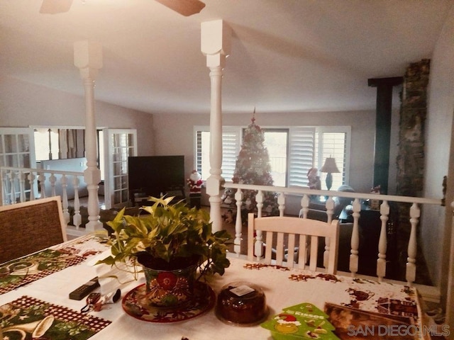 dining area featuring vaulted ceiling and decorative columns