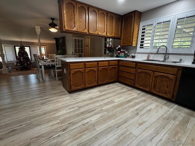 kitchen featuring sink, light hardwood / wood-style flooring, dishwasher, ceiling fan, and kitchen peninsula