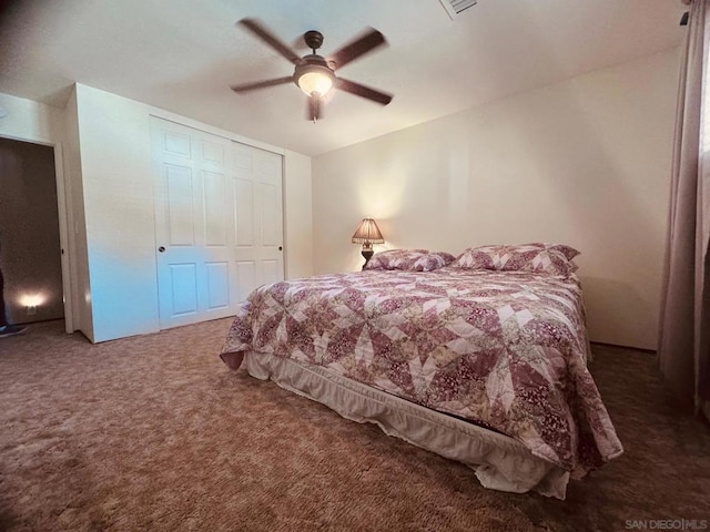 carpeted bedroom featuring ceiling fan and a closet