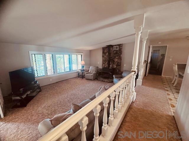 carpeted living room featuring decorative columns