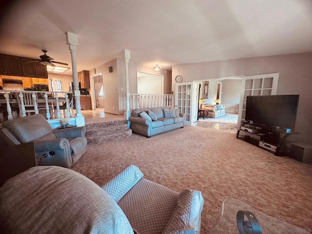 carpeted living room featuring french doors, ceiling fan, and decorative columns