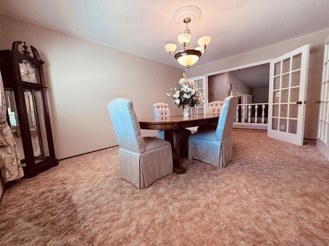 carpeted dining area with a chandelier