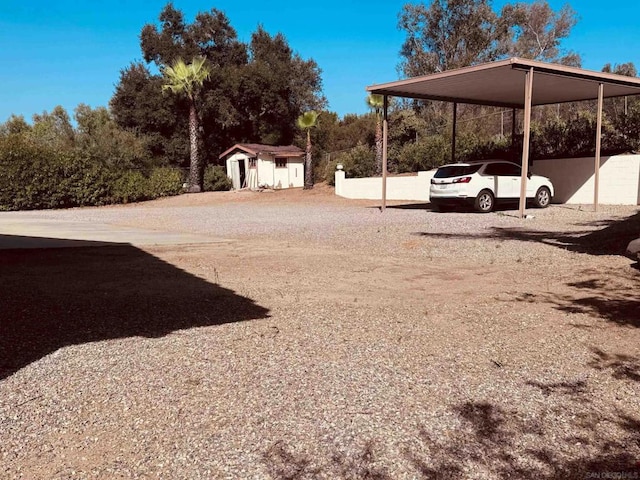 view of yard featuring a carport and a storage shed