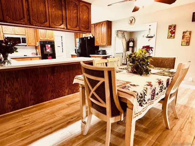 dining space with light hardwood / wood-style flooring and ceiling fan