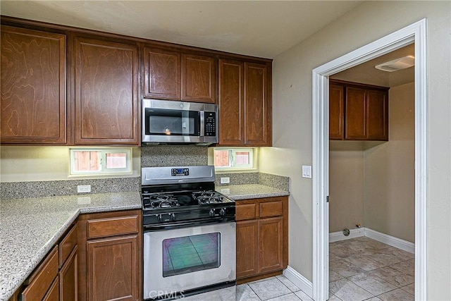 425 Bakeman Ln, Arroyo Grande, CA 93420 - kitchen featuring appliances with stainless steel finishes, light tile patterned floors, backsplash, and light stone counters