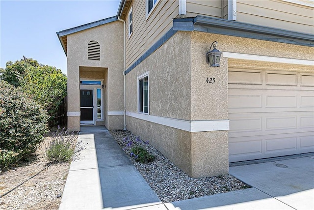 425 Bakeman Ln, Arroyo Grande, CA 93420 - view of exterior entry featuring a garage and stucco siding