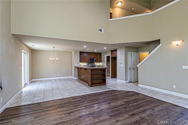 425 Bakeman Ln, Arroyo Grande, CA 93420 - unfurnished living room featuring light wood-type flooring, a chandelier, and a high ceiling