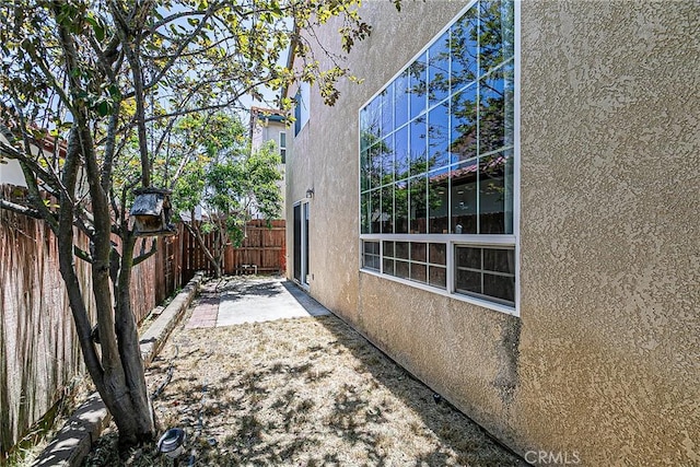 425 Bakeman Ln, Arroyo Grande, CA 93420 - view of side of home featuring stucco siding, a fenced backyard, and a patio