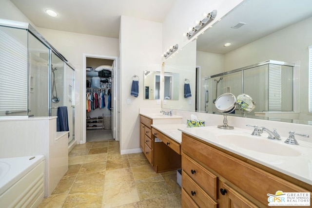 bathroom featuring vanity and independent shower and bath