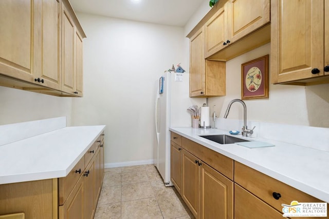 kitchen featuring light brown cabinets, light tile patterned floors, and sink