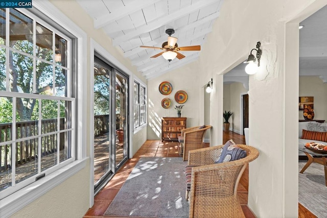 sunroom / solarium with vaulted ceiling with beams, wood ceiling, and ceiling fan