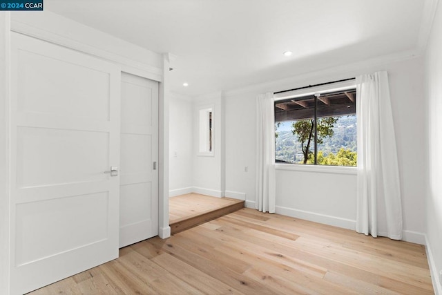 unfurnished bedroom featuring light hardwood / wood-style floors and ornamental molding