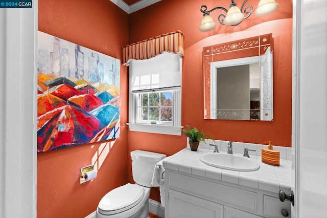 bathroom with vanity, toilet, and crown molding