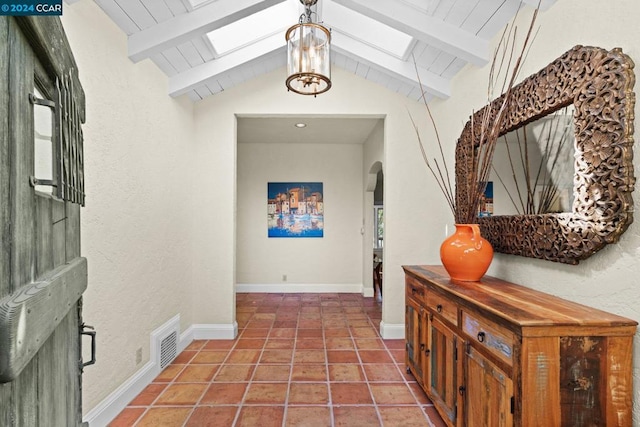 hall with vaulted ceiling with skylight, an inviting chandelier, wooden ceiling, and tile patterned floors