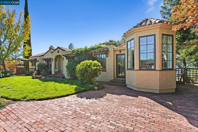 view of front of home with a patio area and a front lawn