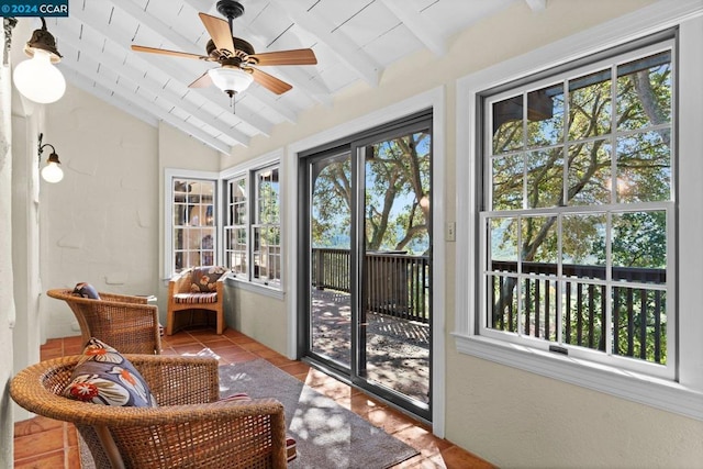 sunroom featuring lofted ceiling with beams, ceiling fan, and a wealth of natural light