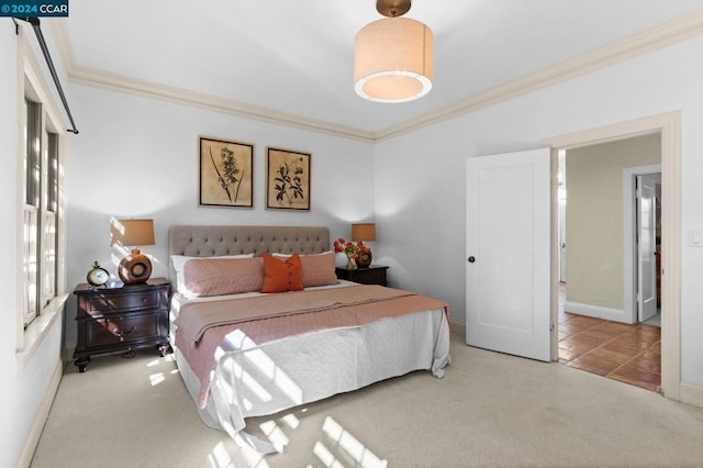 bedroom with ornamental molding and light colored carpet