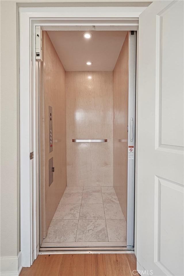 bathroom featuring hardwood / wood-style flooring and elevator