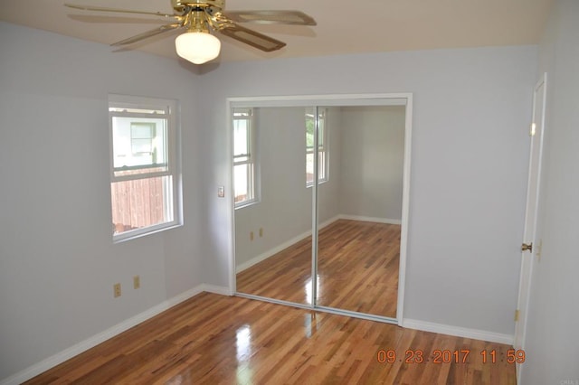 unfurnished bedroom with a closet, hardwood / wood-style floors, and ceiling fan