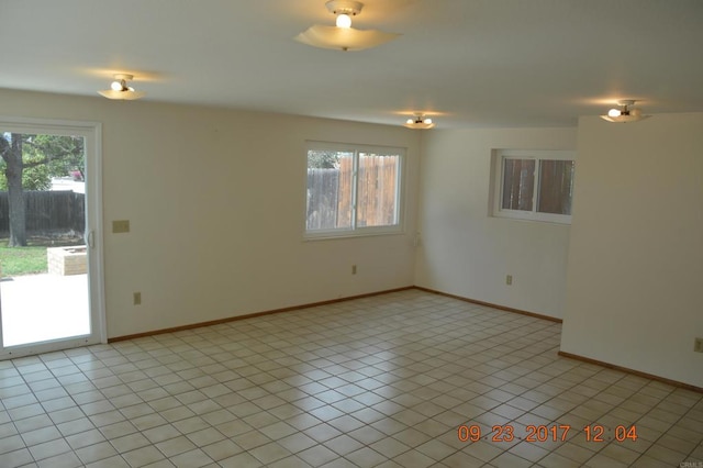 empty room with light tile patterned floors and plenty of natural light