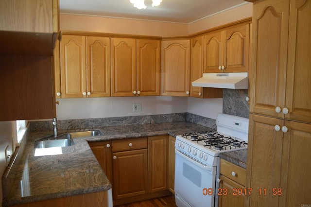 kitchen with sink, white gas range, and dark stone counters